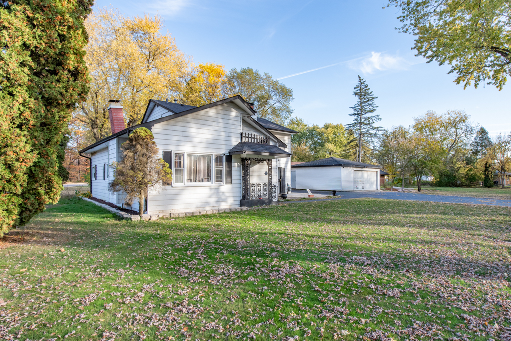 a view of a house with a big yard and large trees