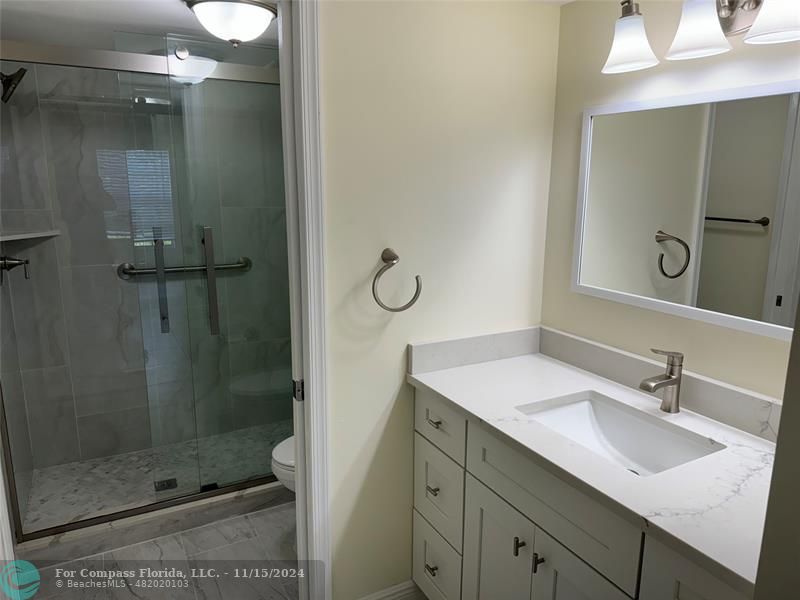 a bathroom with a shower sink and mirror