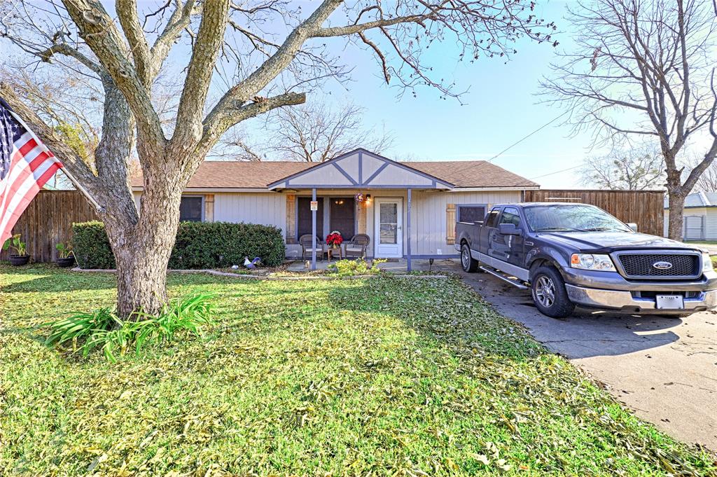 a front view of a house with a garden and trees