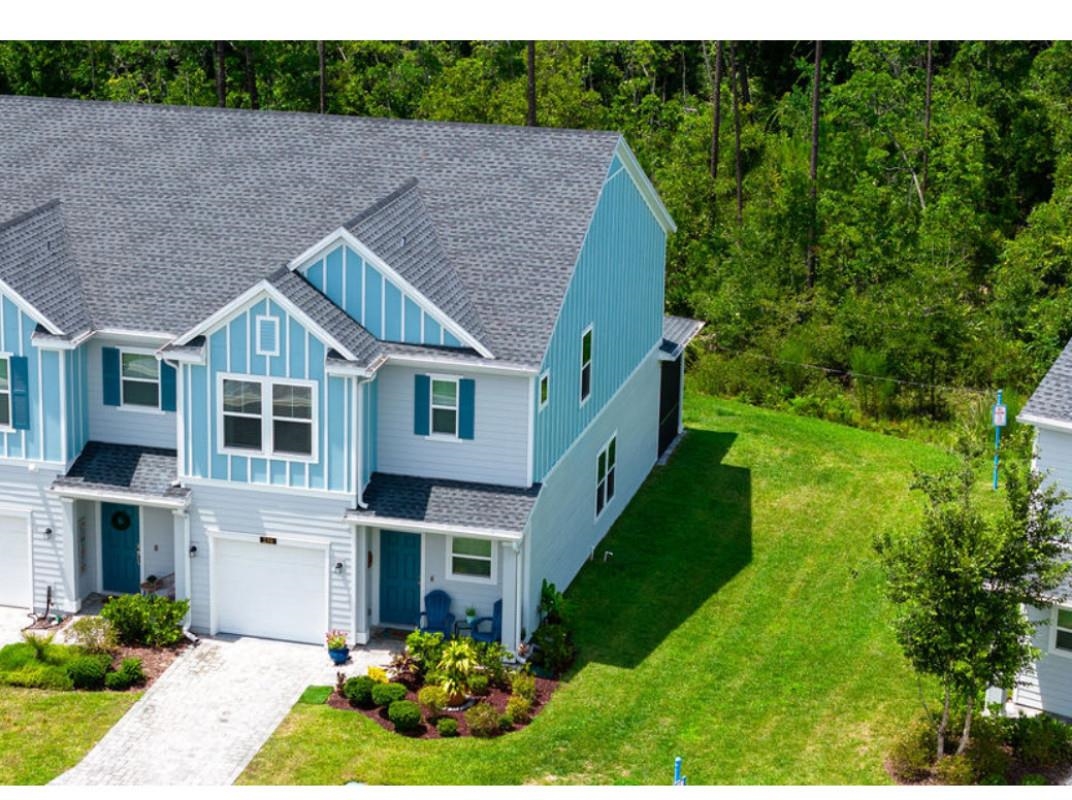 a aerial view of a house next to a big yard and large trees