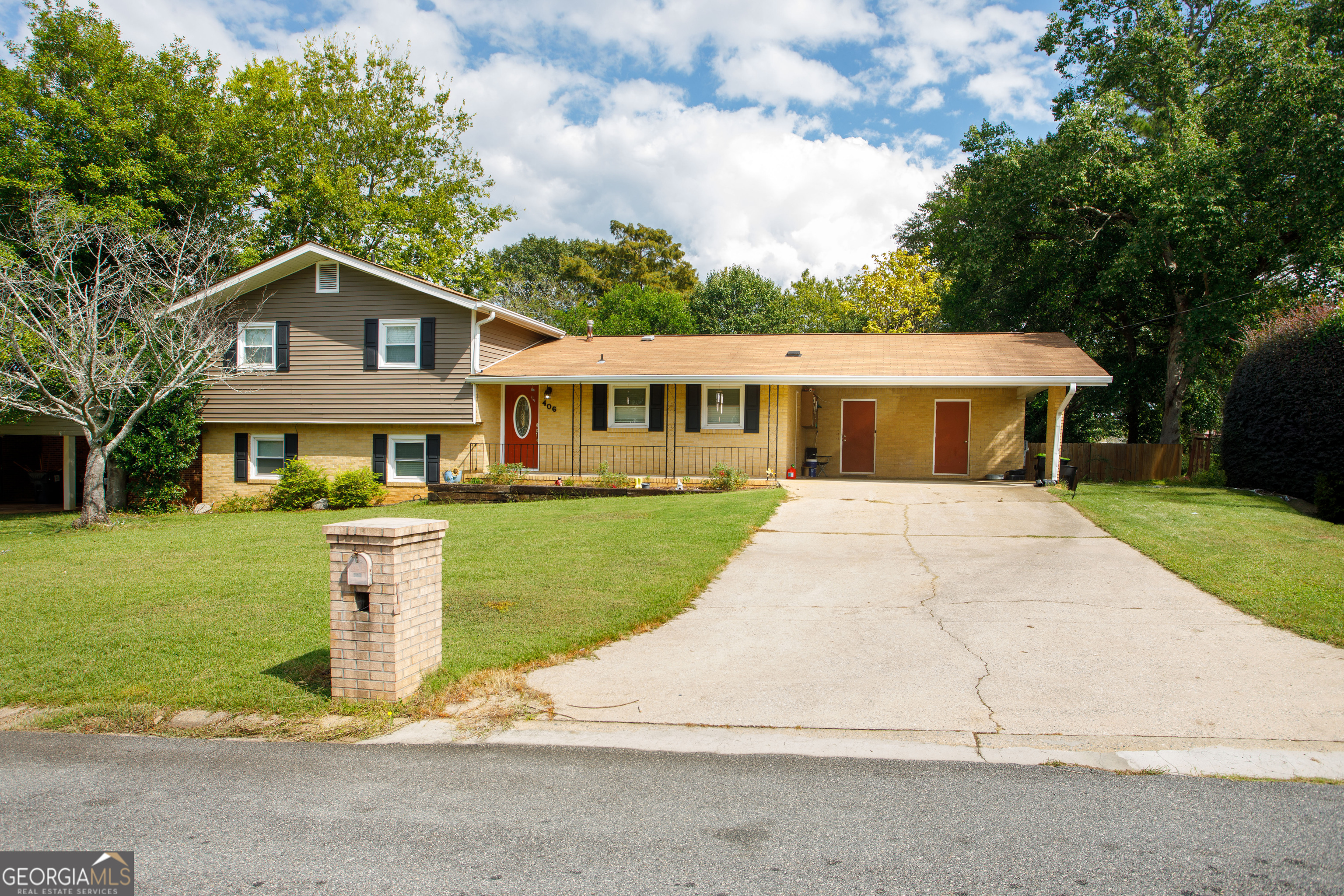 a front view of a house with a yard and trees