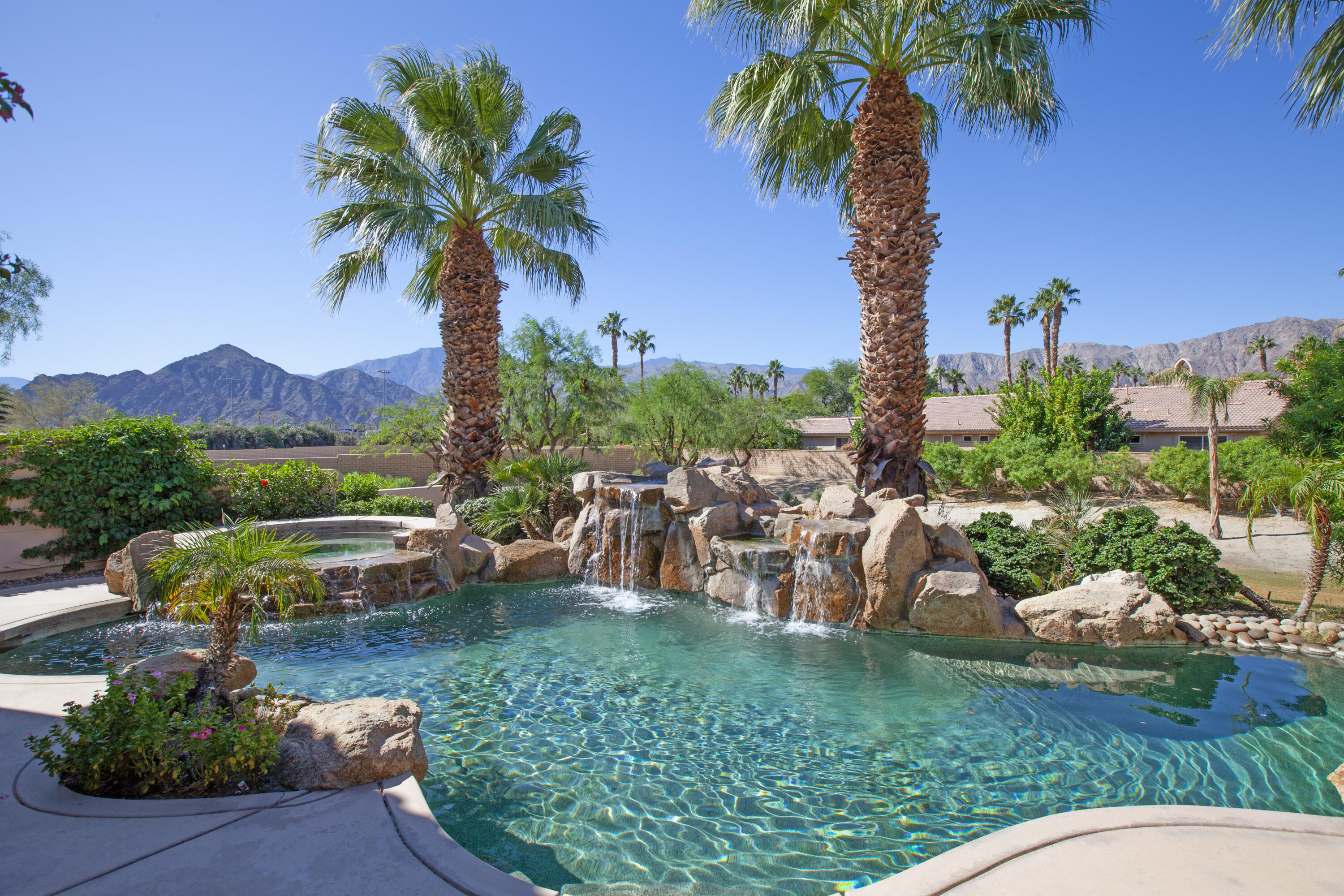 a view of a backyard with couches under an umbrella