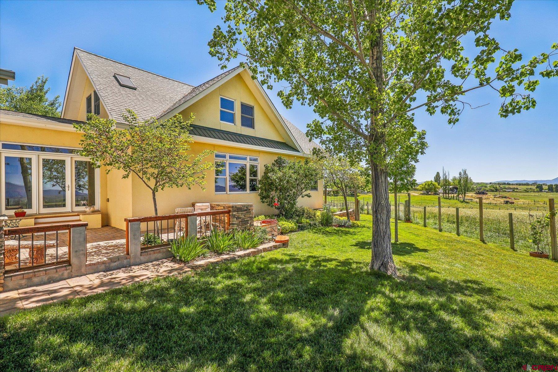 a view of a house with backyard and a tree