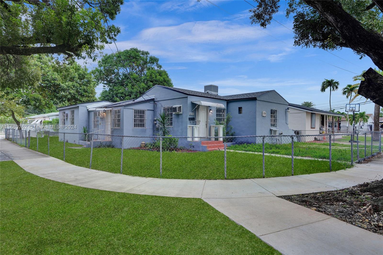 a view of a big house with a big yard and large trees