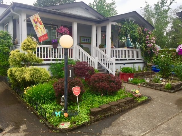 a front view of a house having yard and a garden