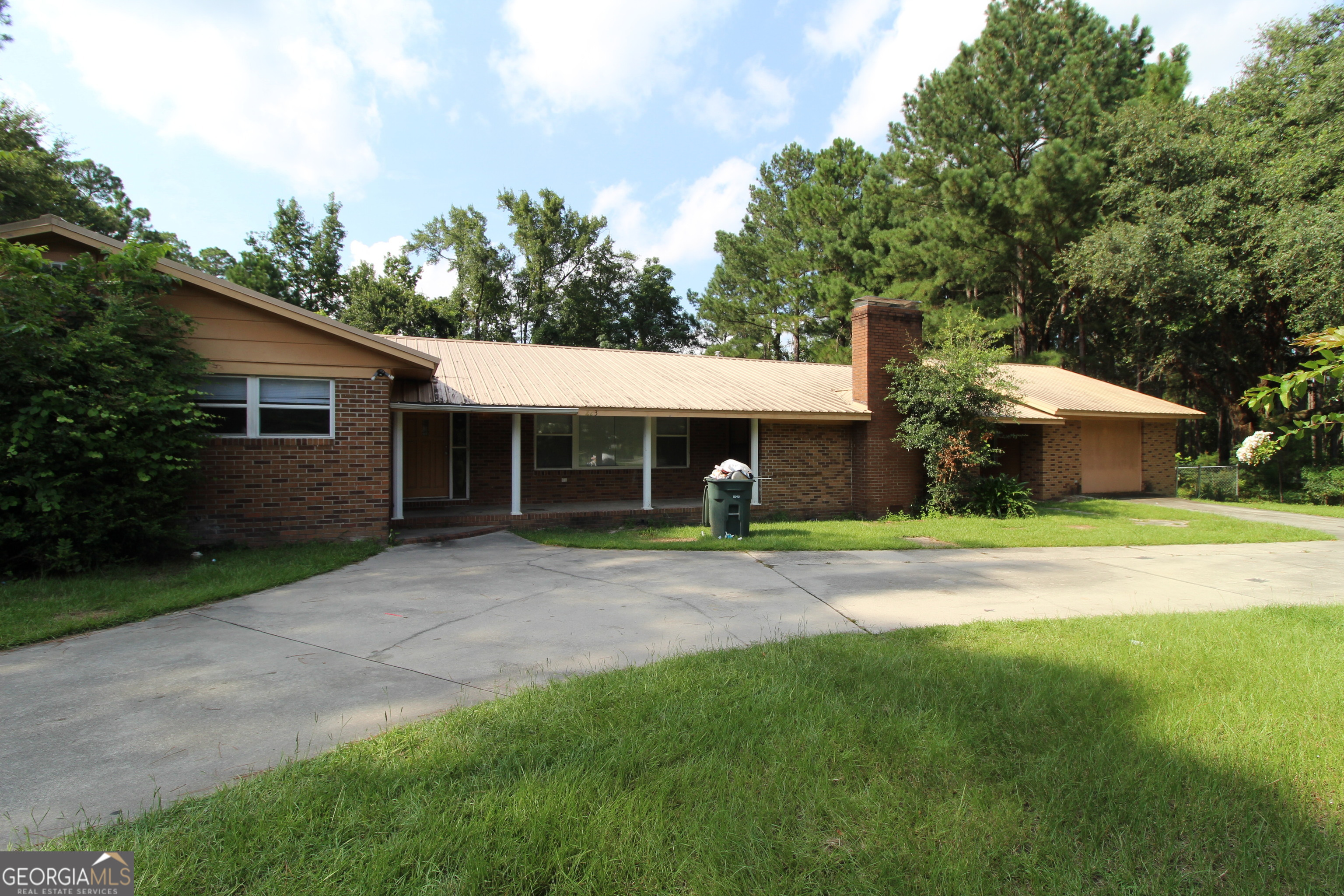 a front view of a house with a yard and trees