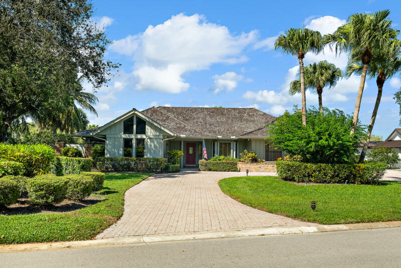 a front view of a house with a garden and trees