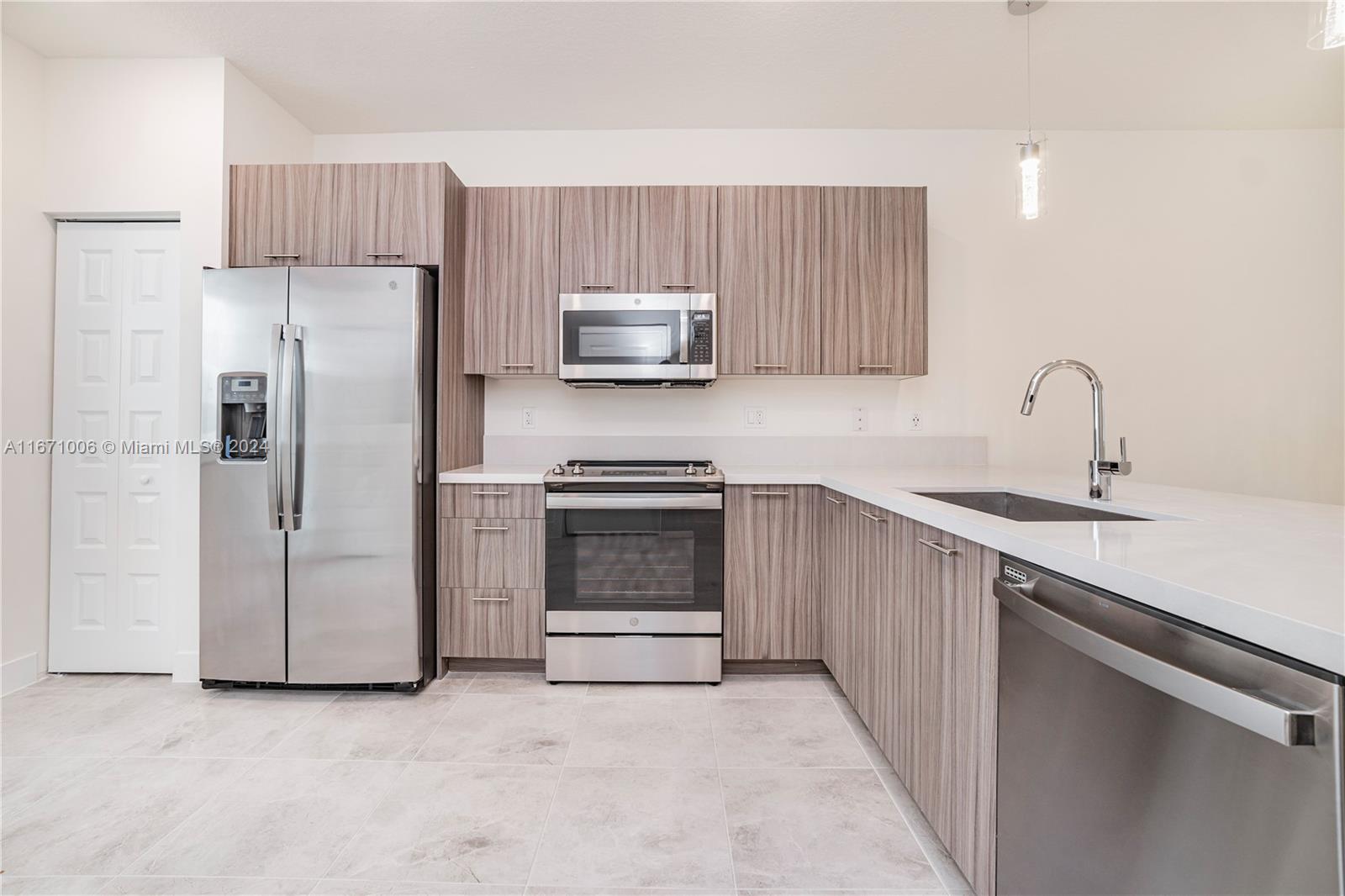 a kitchen with stainless steel appliances a refrigerator sink and microwave