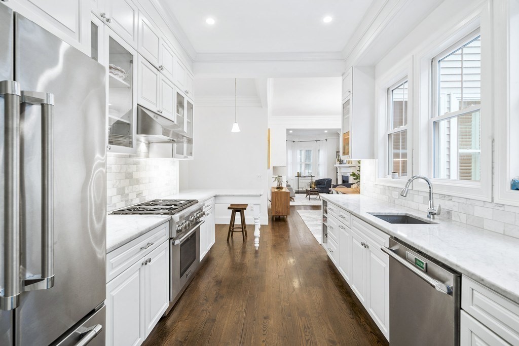 a large kitchen with stainless steel appliances granite countertop a lot of counter space and wooden floors