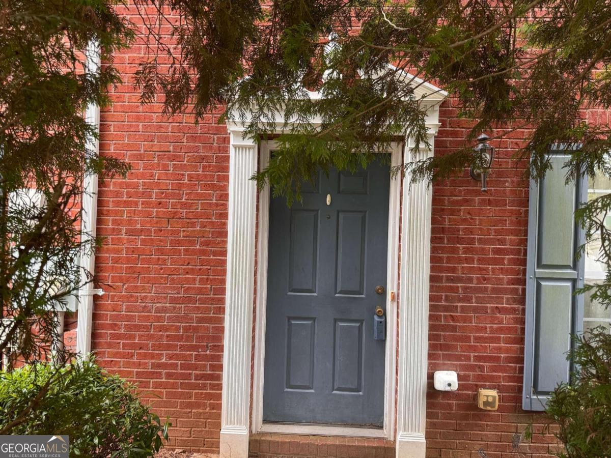 a view of a brick house with a tree