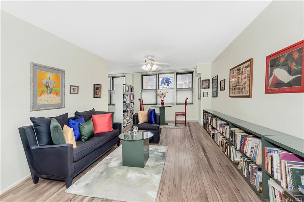 Living room with ceiling fan and hardwood / wood-style floors