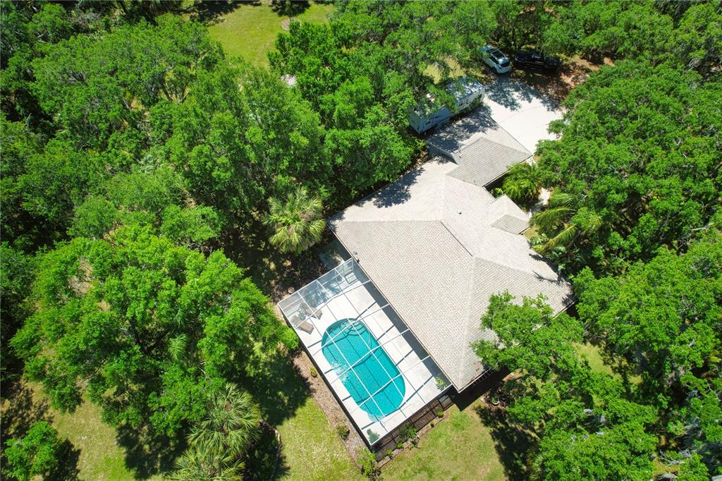 an aerial view of a house with a yard and trees