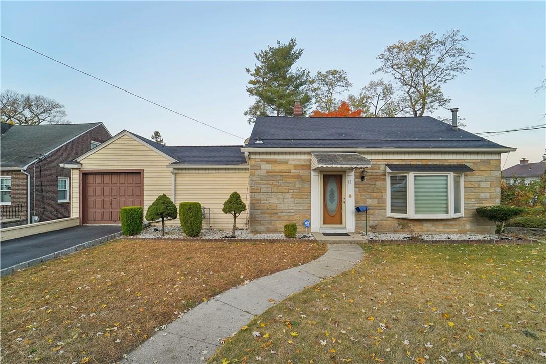 View of front of house featuring a garage and a front yard