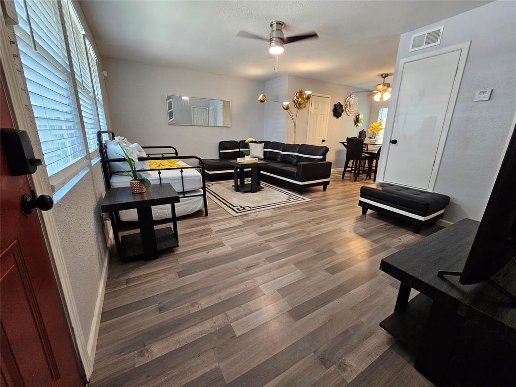 a living room with furniture and a wooden floor