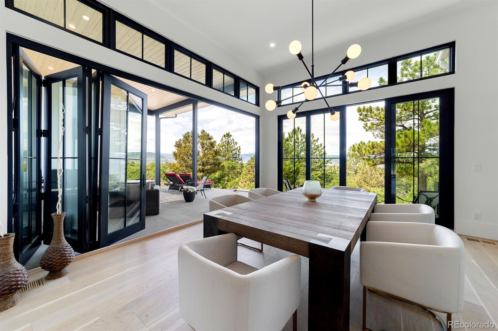 a dining room with wooden floor furniture and a chandelier