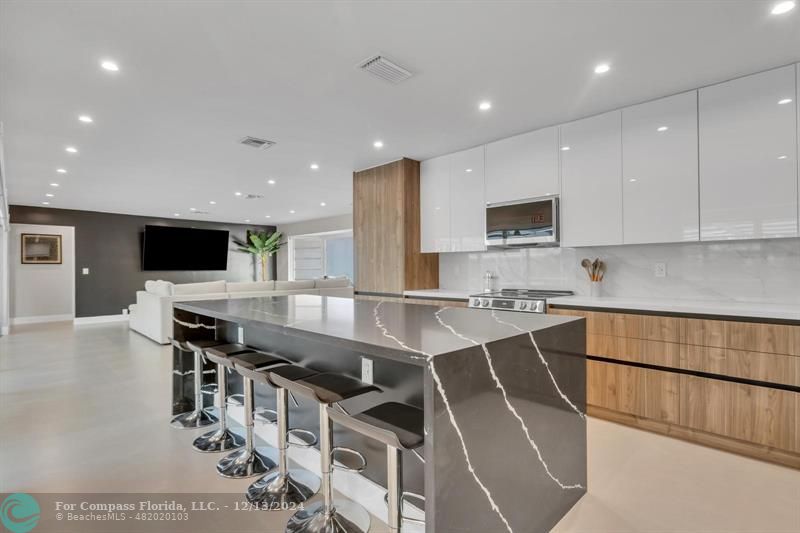 a large kitchen with stainless steel appliances lots of counter space and wooden floor