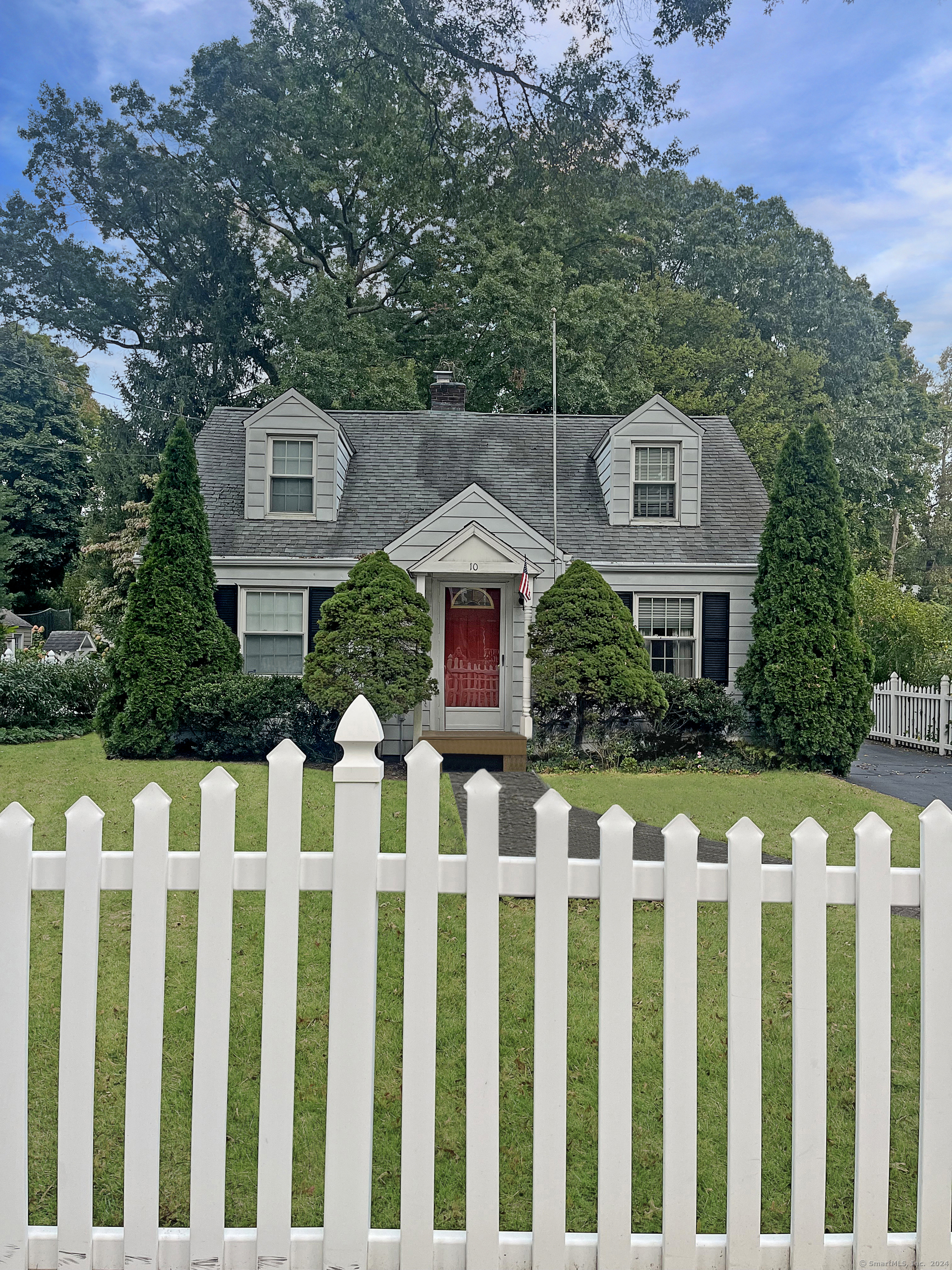 a front view of white house with a garden