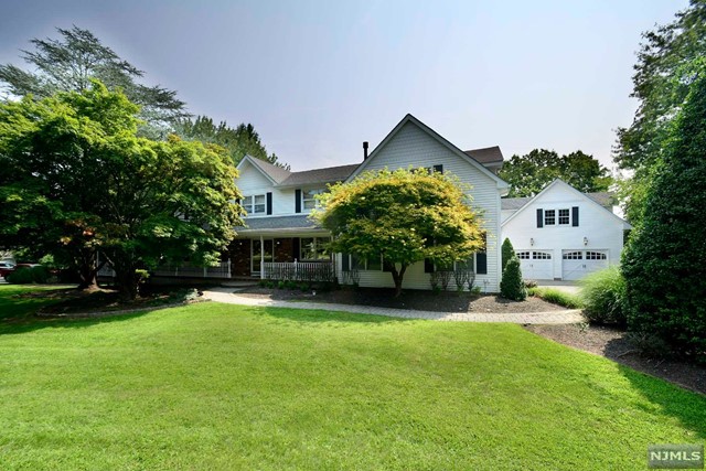 a front view of a house with a yard and trees