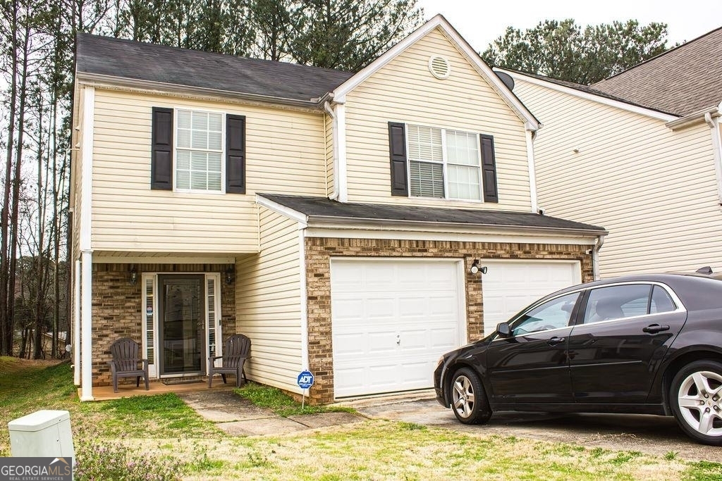 a view of a house with a yard and furniture