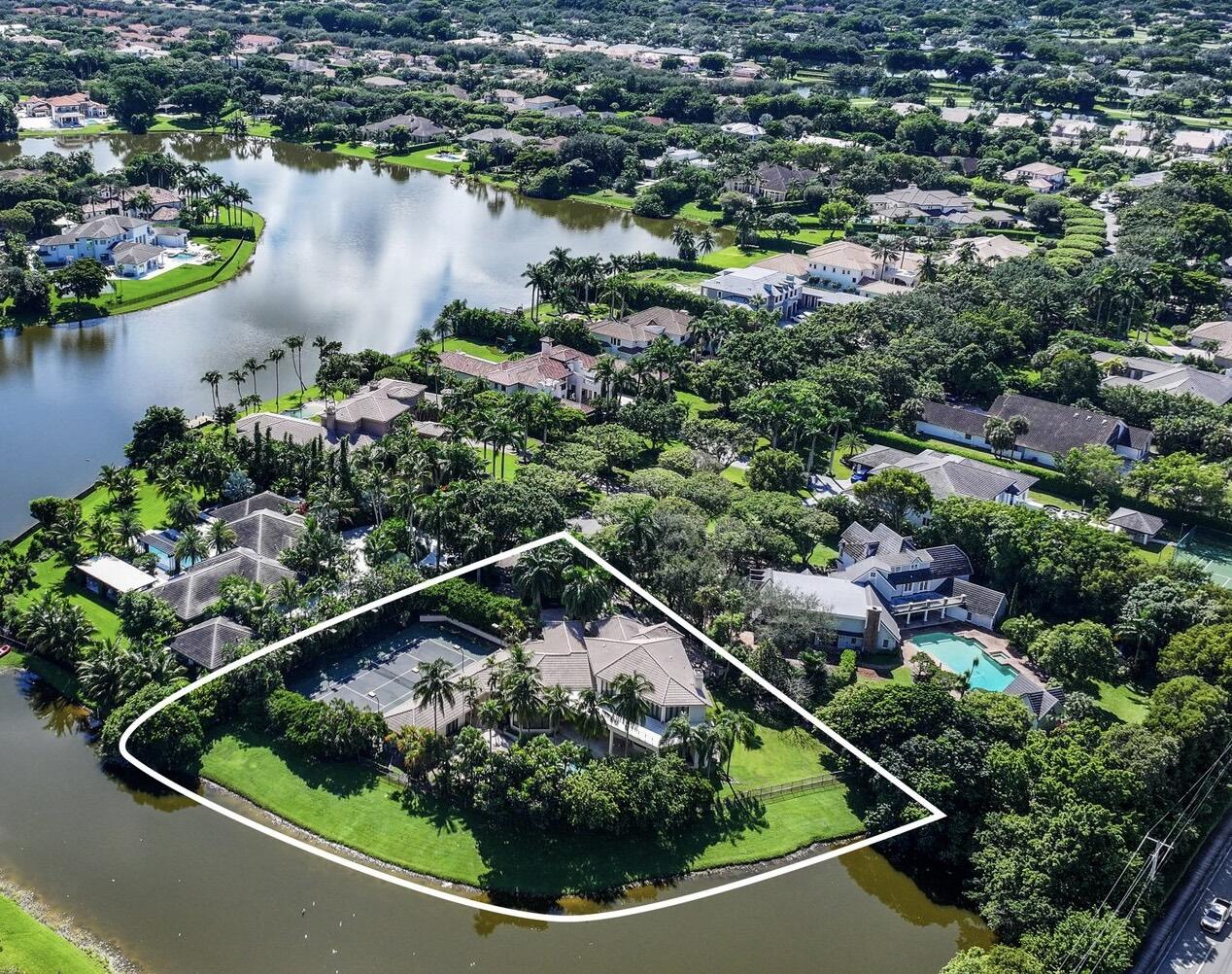 an aerial view of a houses with a yard and lake view