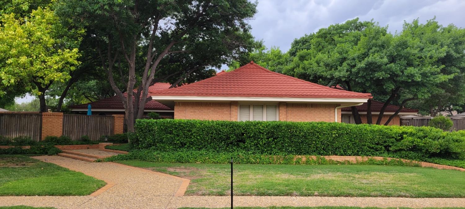 a front view of a house with a yard and trees