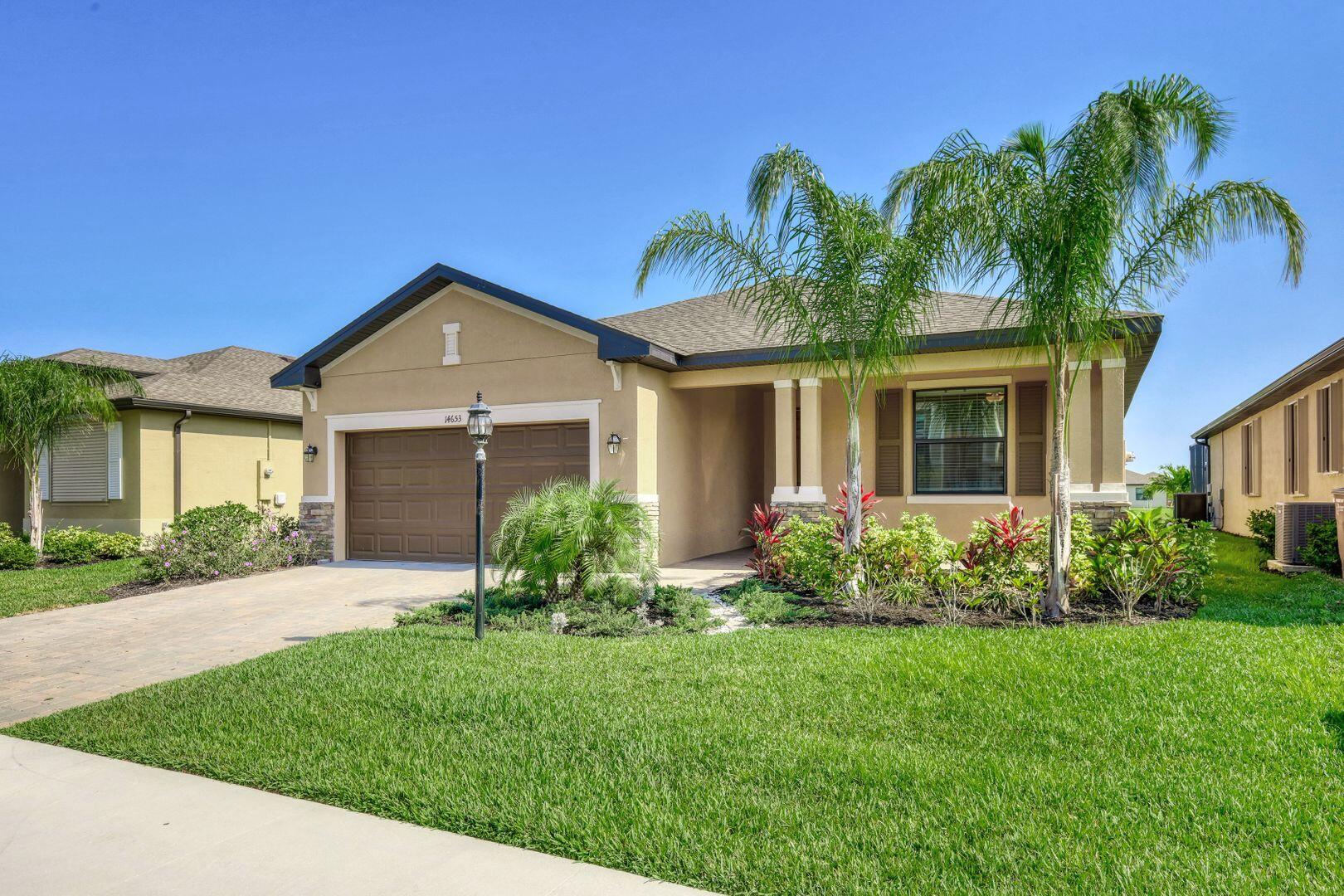 a front view of a house with a garden and plants