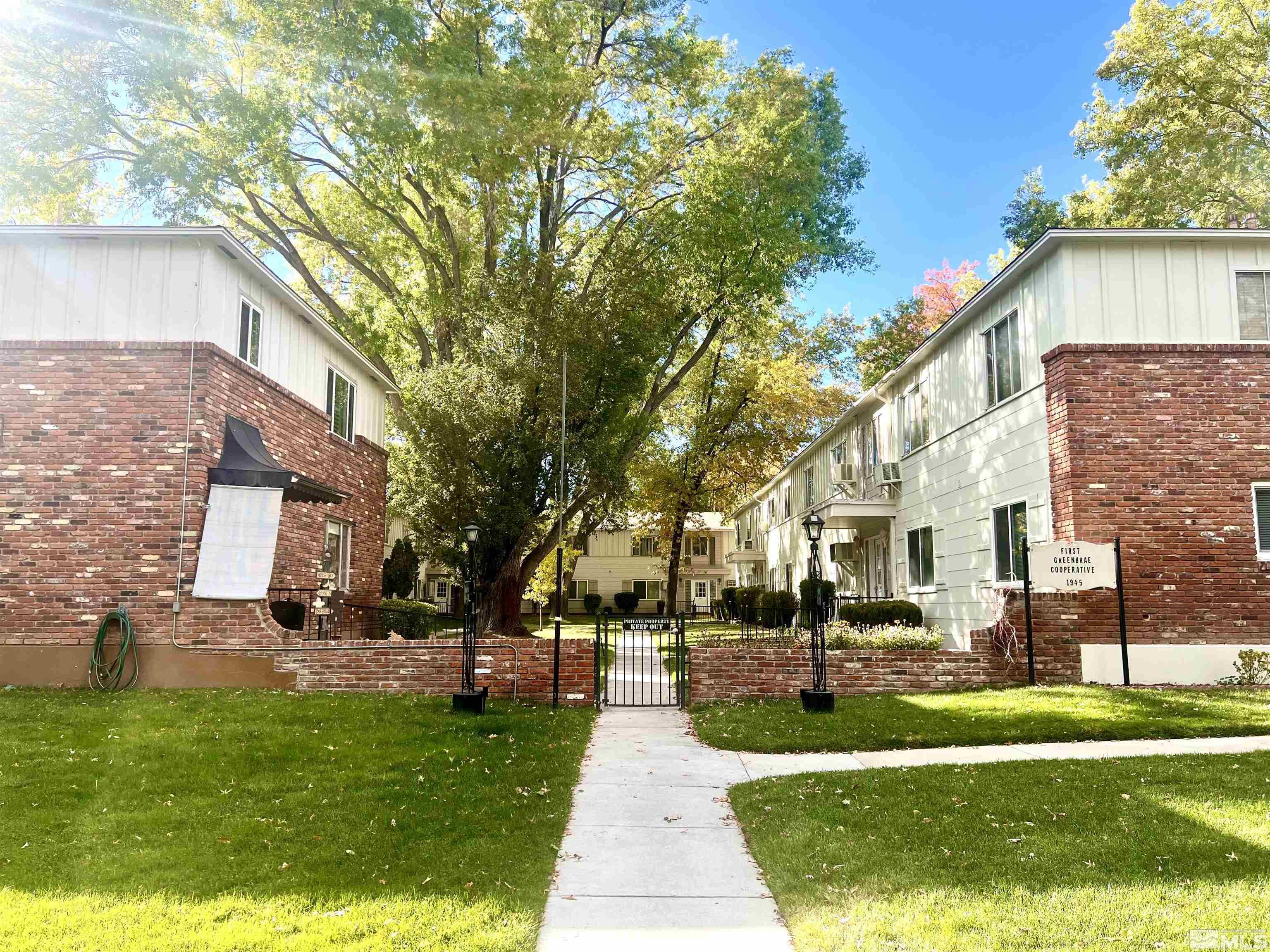 a front view of a building with a garden