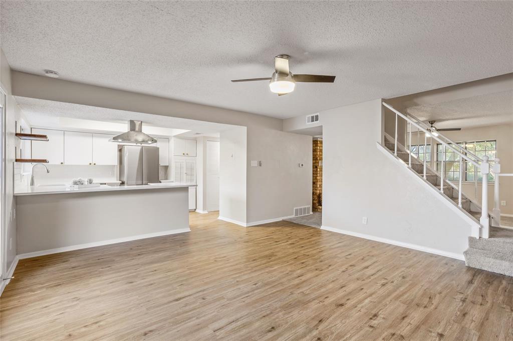 a view of large kitchen with wooden floor and staircase