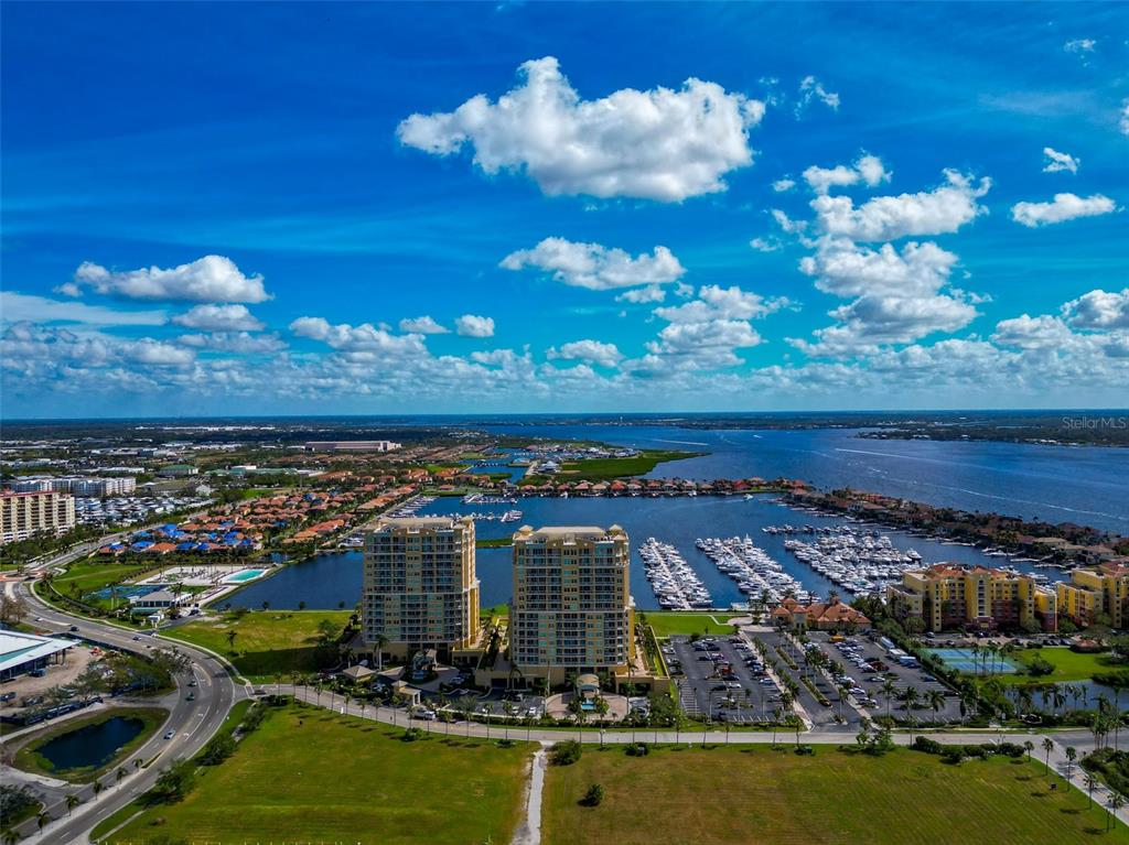 a view of a city with lots of residential buildings ocean and mountain view in back