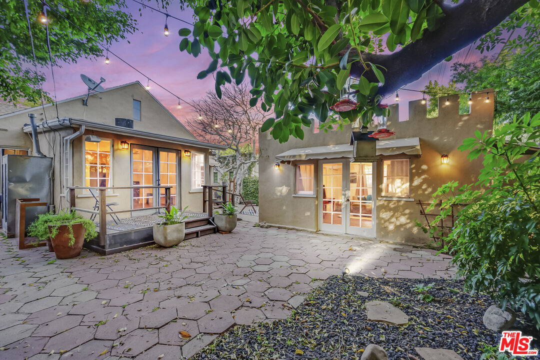 a backyard of a house with barbeque oven table and chairs