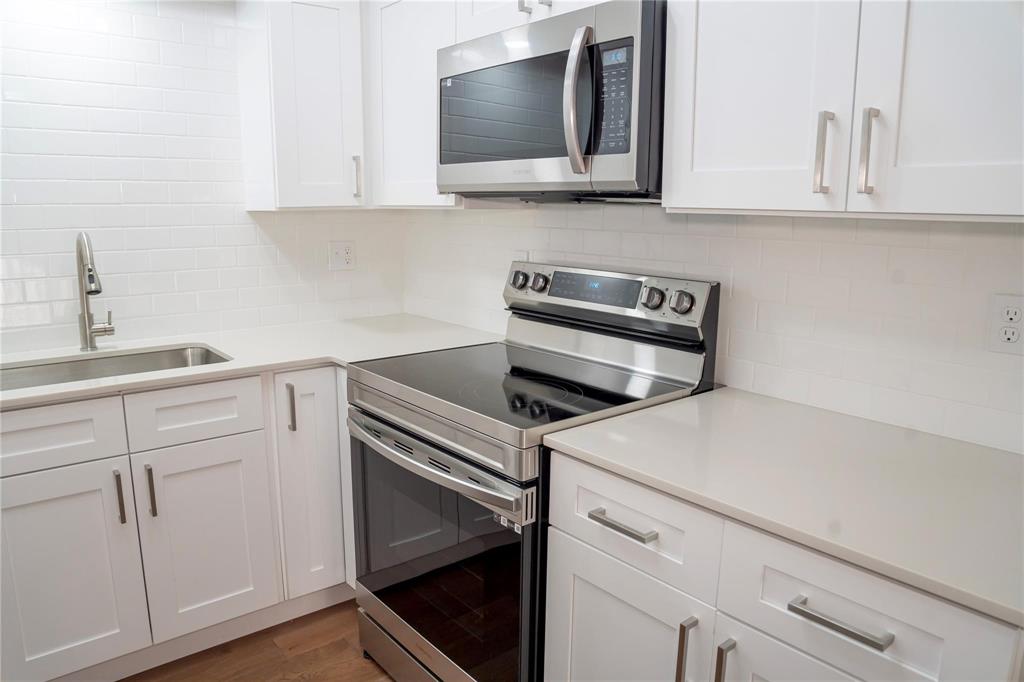 a kitchen with white cabinets and appliances