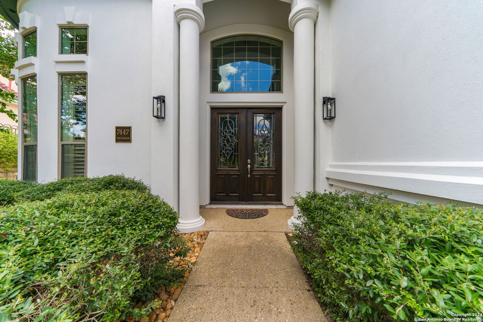 a front view of a house with a garden