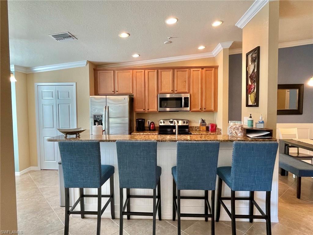 a kitchen with kitchen island a dining table and chairs