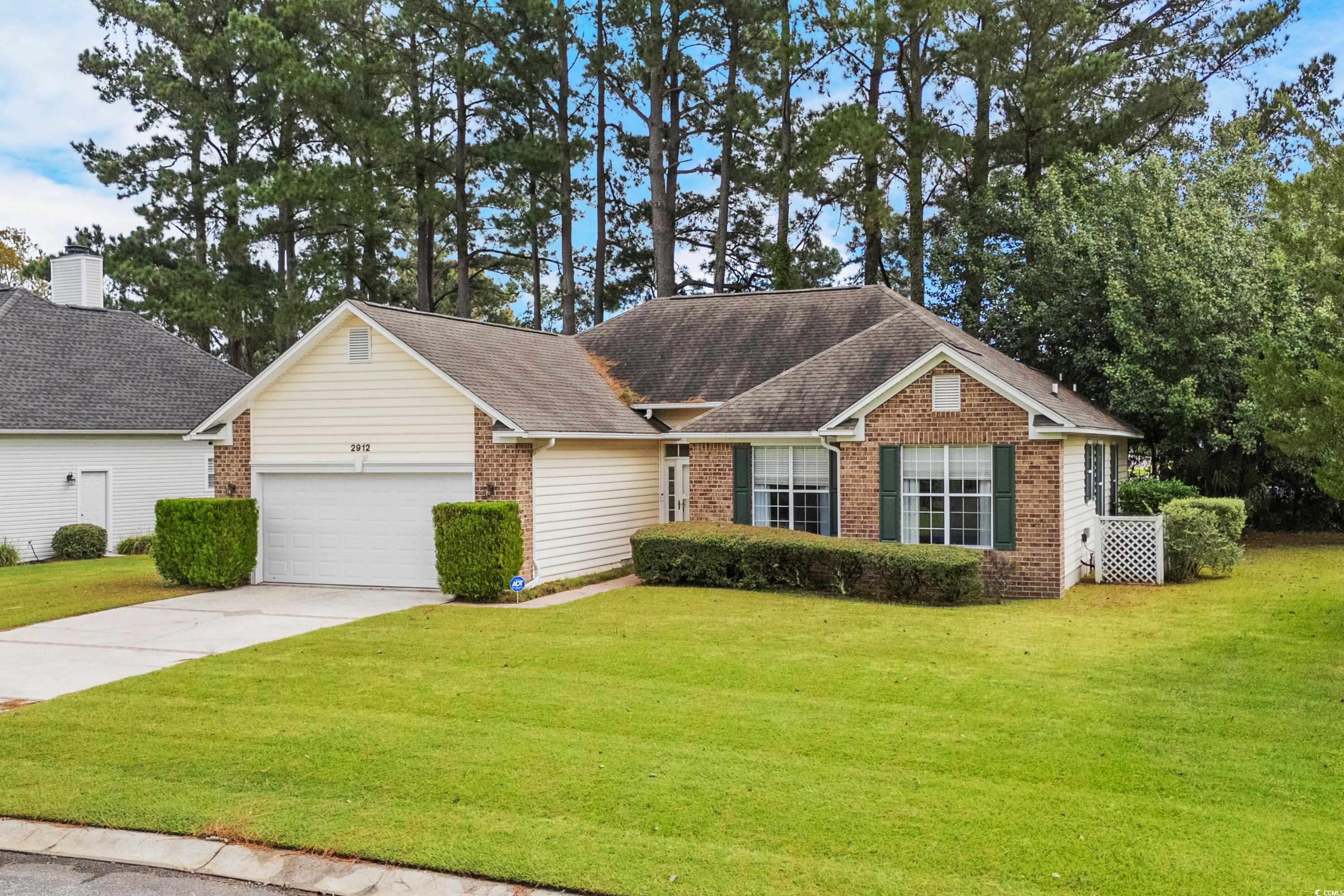 Ranch-style house featuring a front yard and a gar