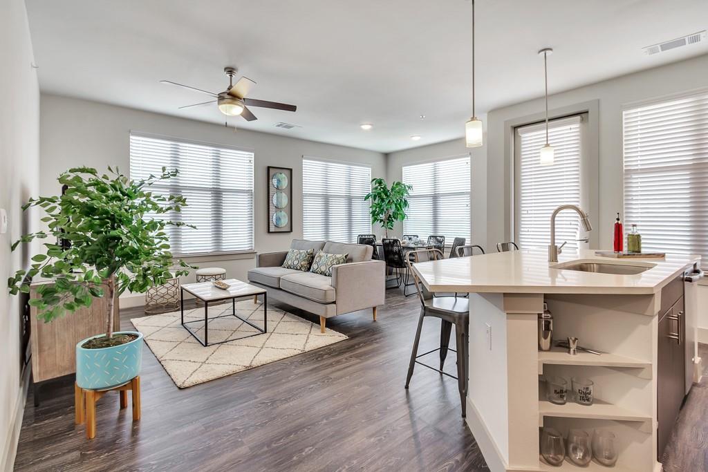 a living room with furniture a chandelier and a potted plant