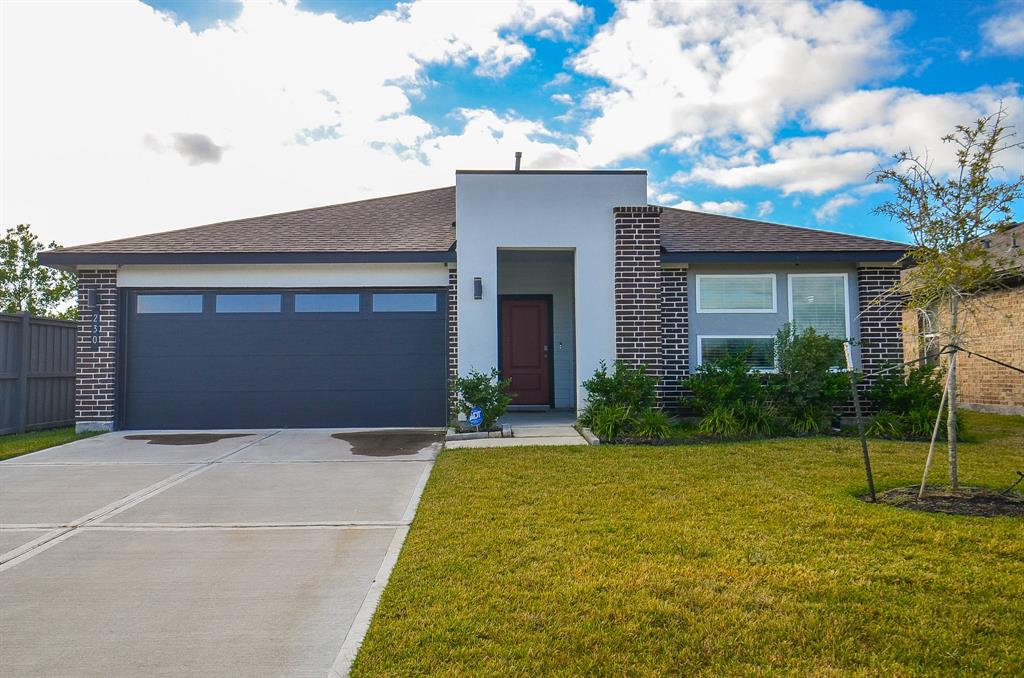 Modern single-story home featuring a two-car garage, neat landscaping, and a mix of brick and siding exterior with a welcoming entrance.