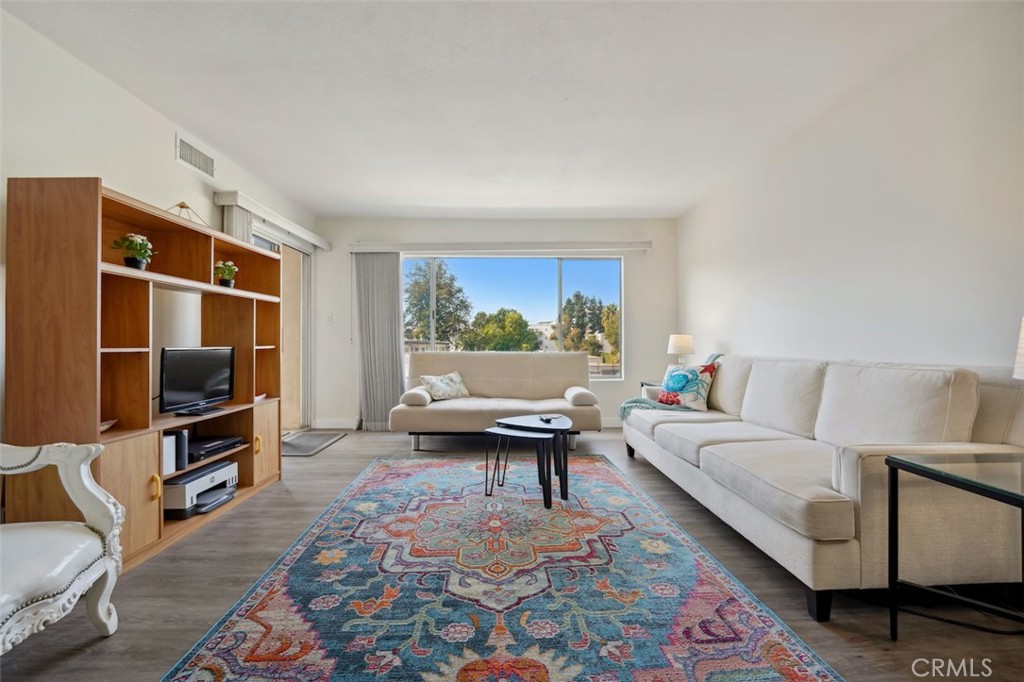 a living room with furniture a rug and a flat screen tv