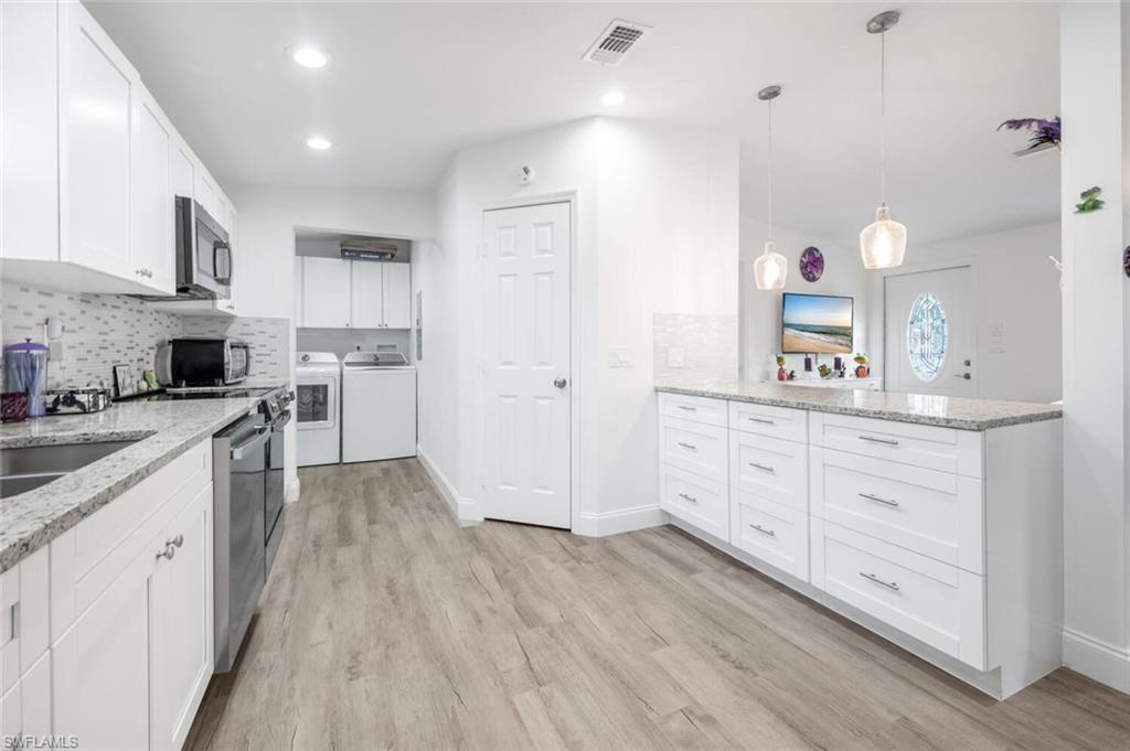 a kitchen with white cabinets and stainless steel appliances