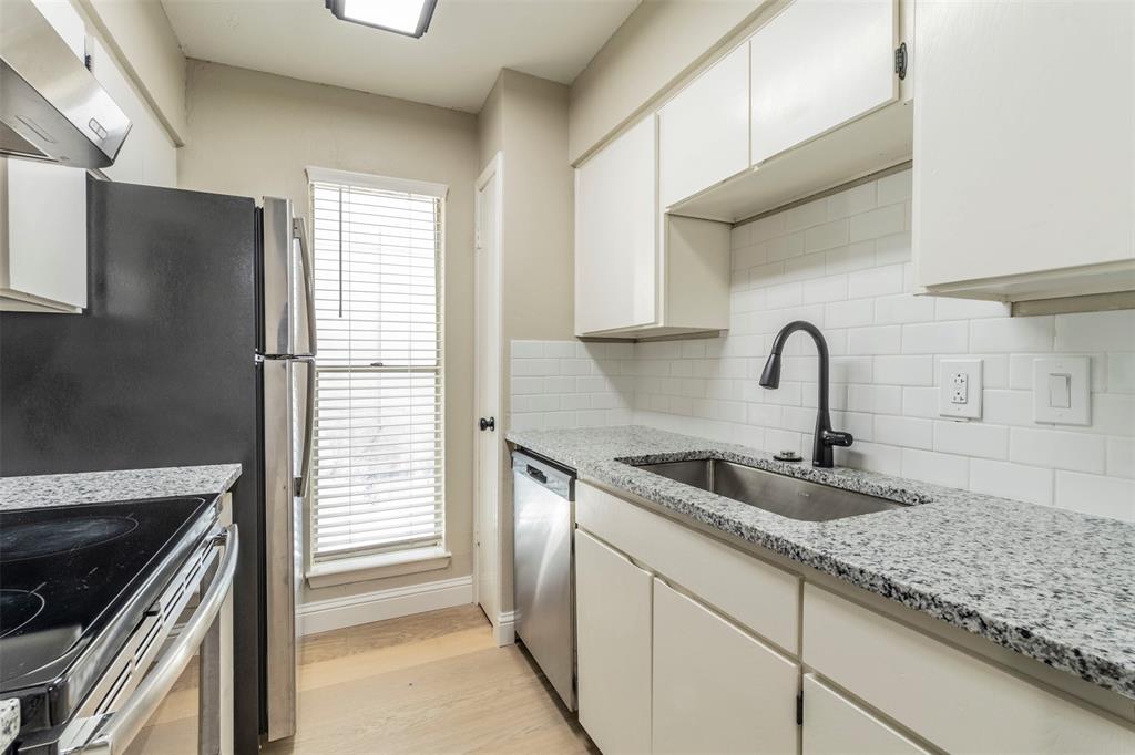 a kitchen with granite countertop a sink and a stove top oven