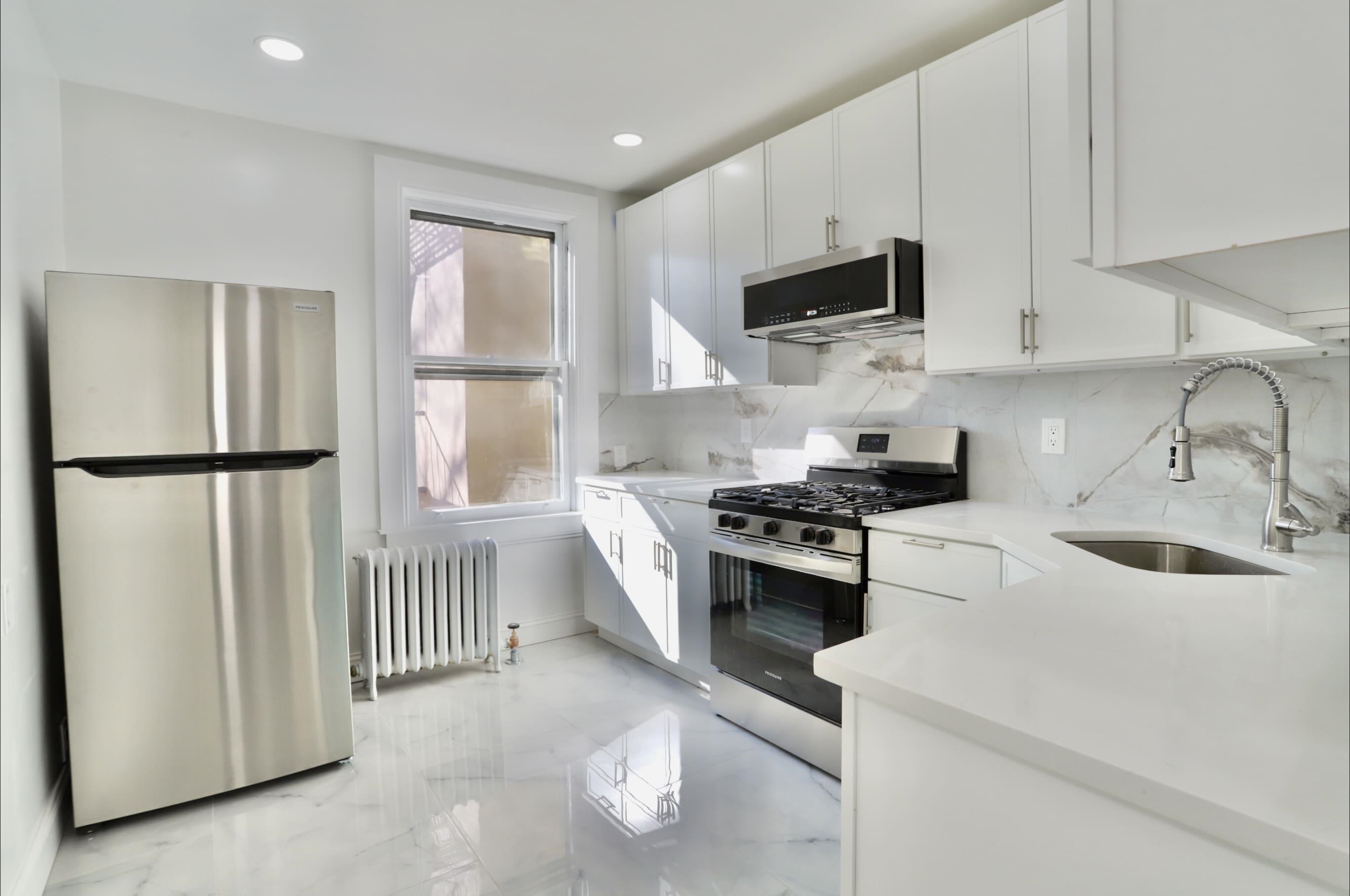 a kitchen with stainless steel appliances granite countertop a sink stove and refrigerator