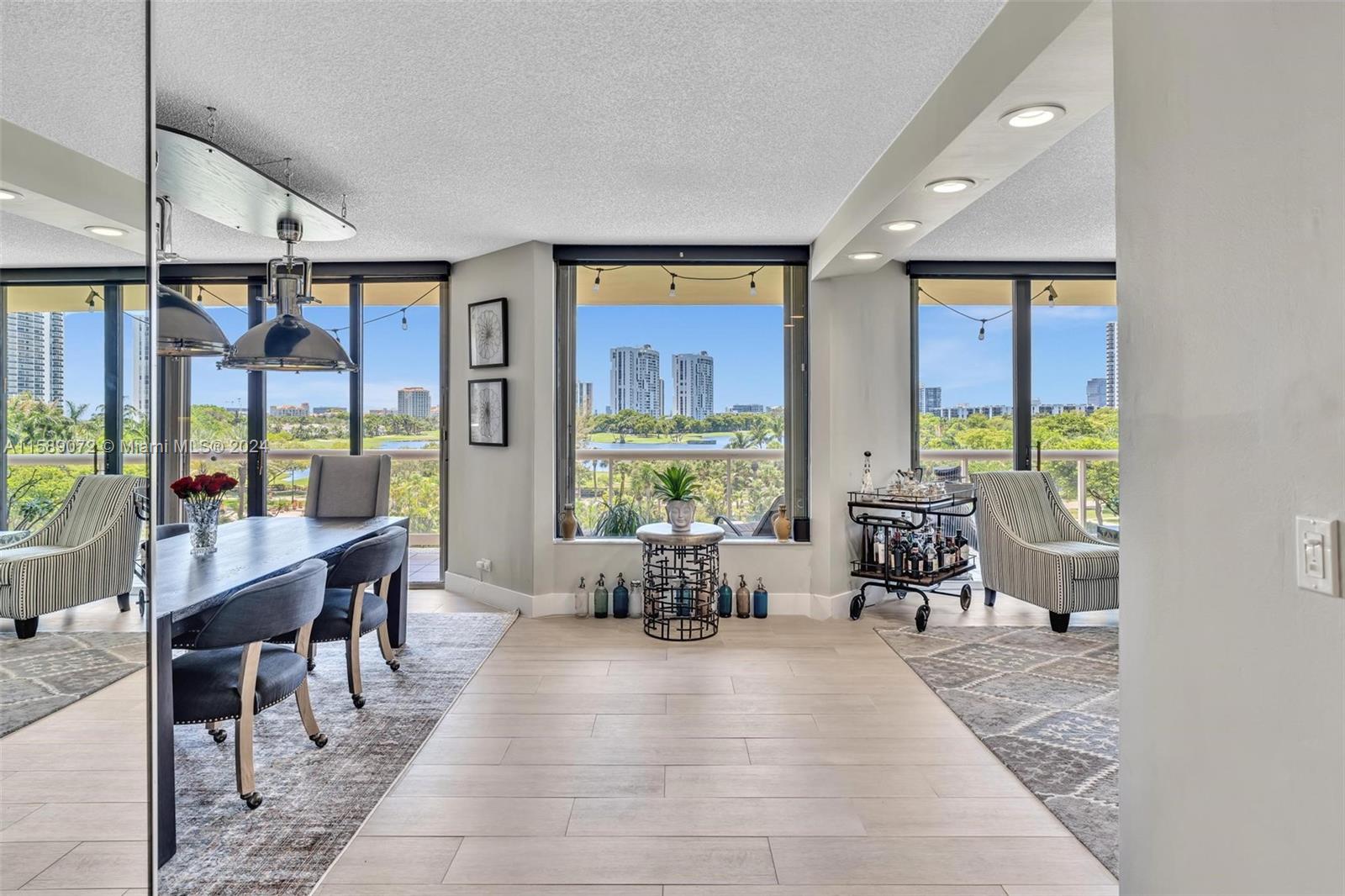 a living room with furniture tv and large windows