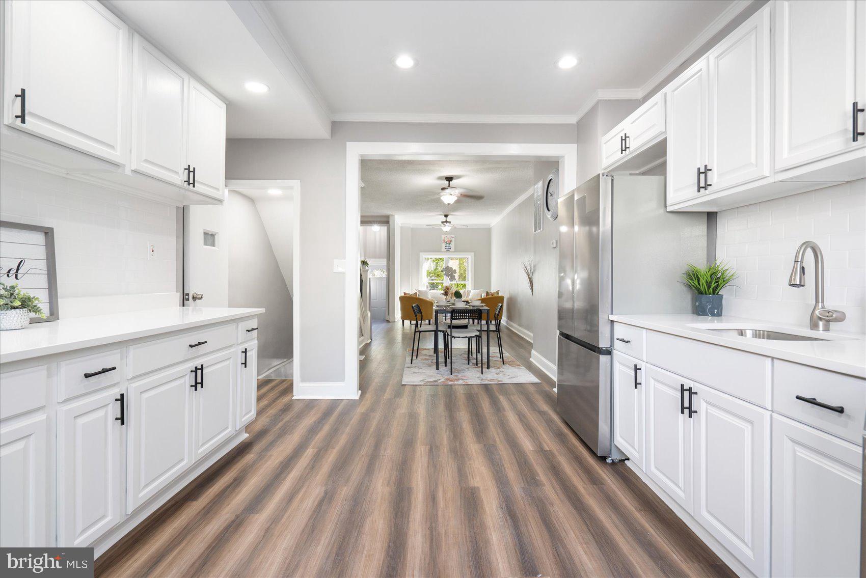 a kitchen with white cabinets stainless steel appliances