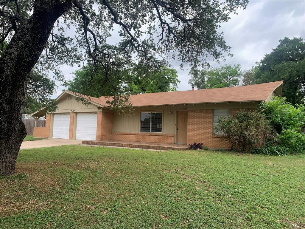 a house that has a tree in front of it