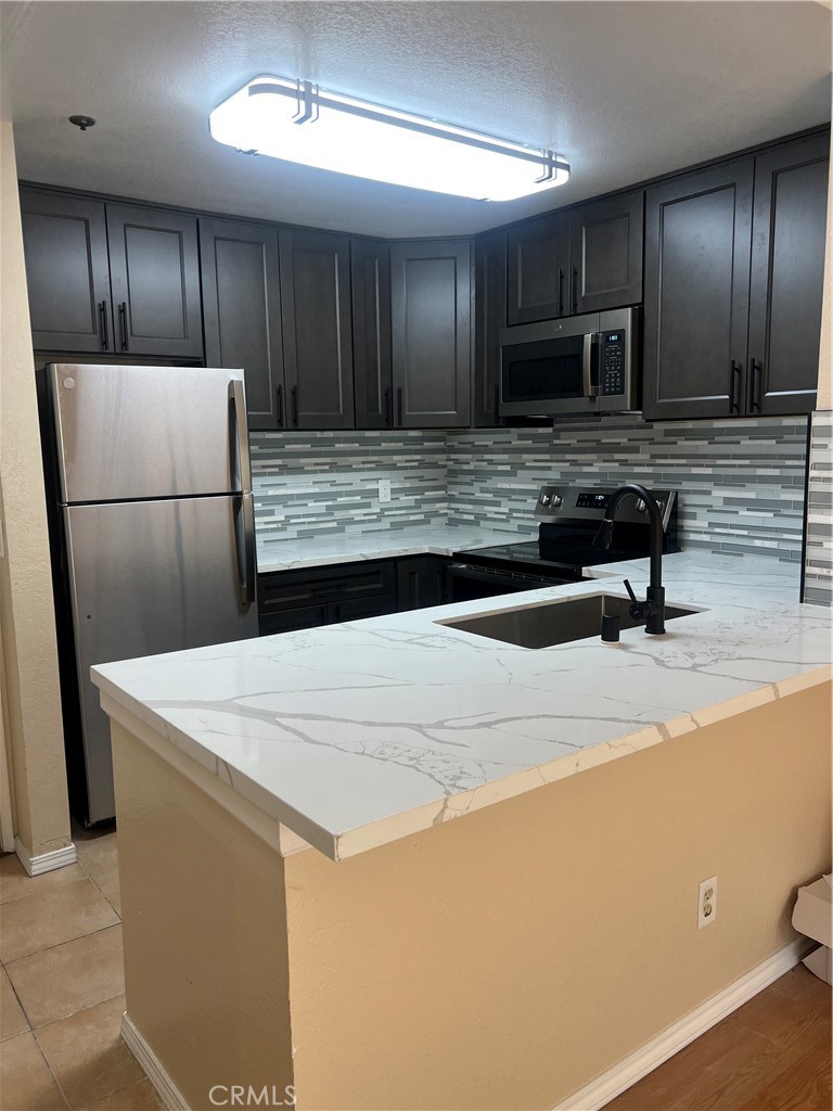 a kitchen with kitchen island wooden cabinets a refrigerator and a sink