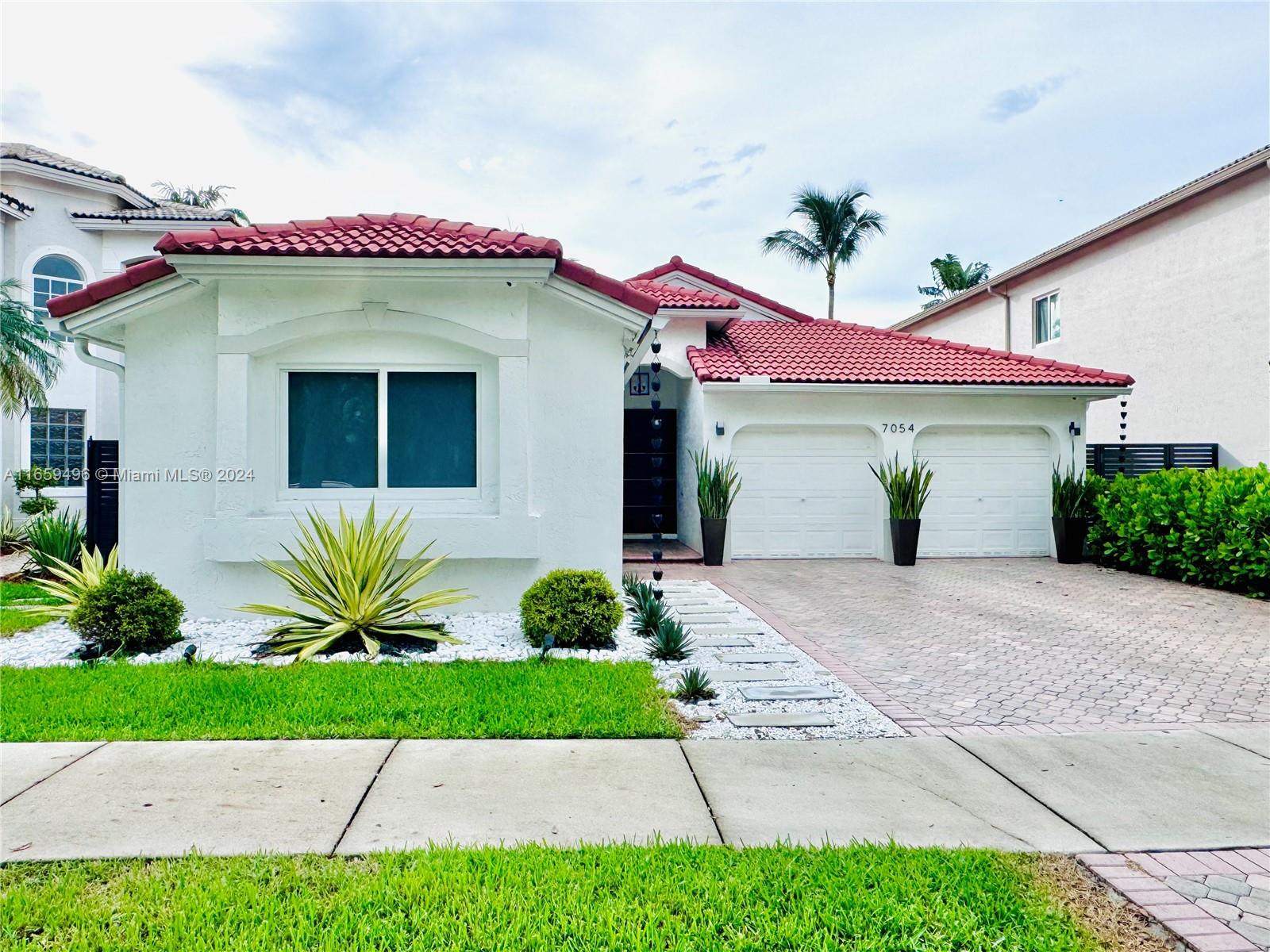 a front view of a house with a garden