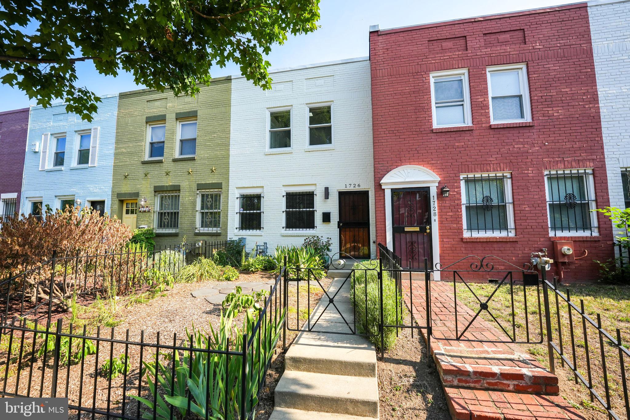 a view of a brick house with many windows next to a yard