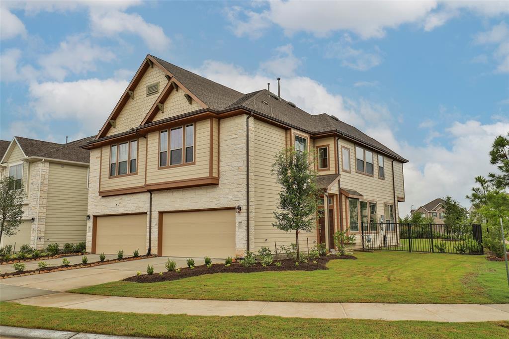 a view of a big house with a yard and plants