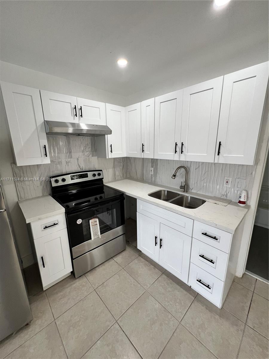 a kitchen with cabinets appliances and a sink