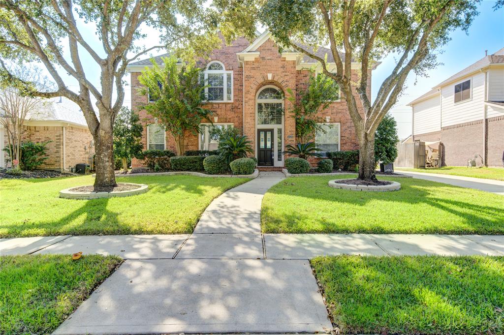 a front view of a house with a yard and plants