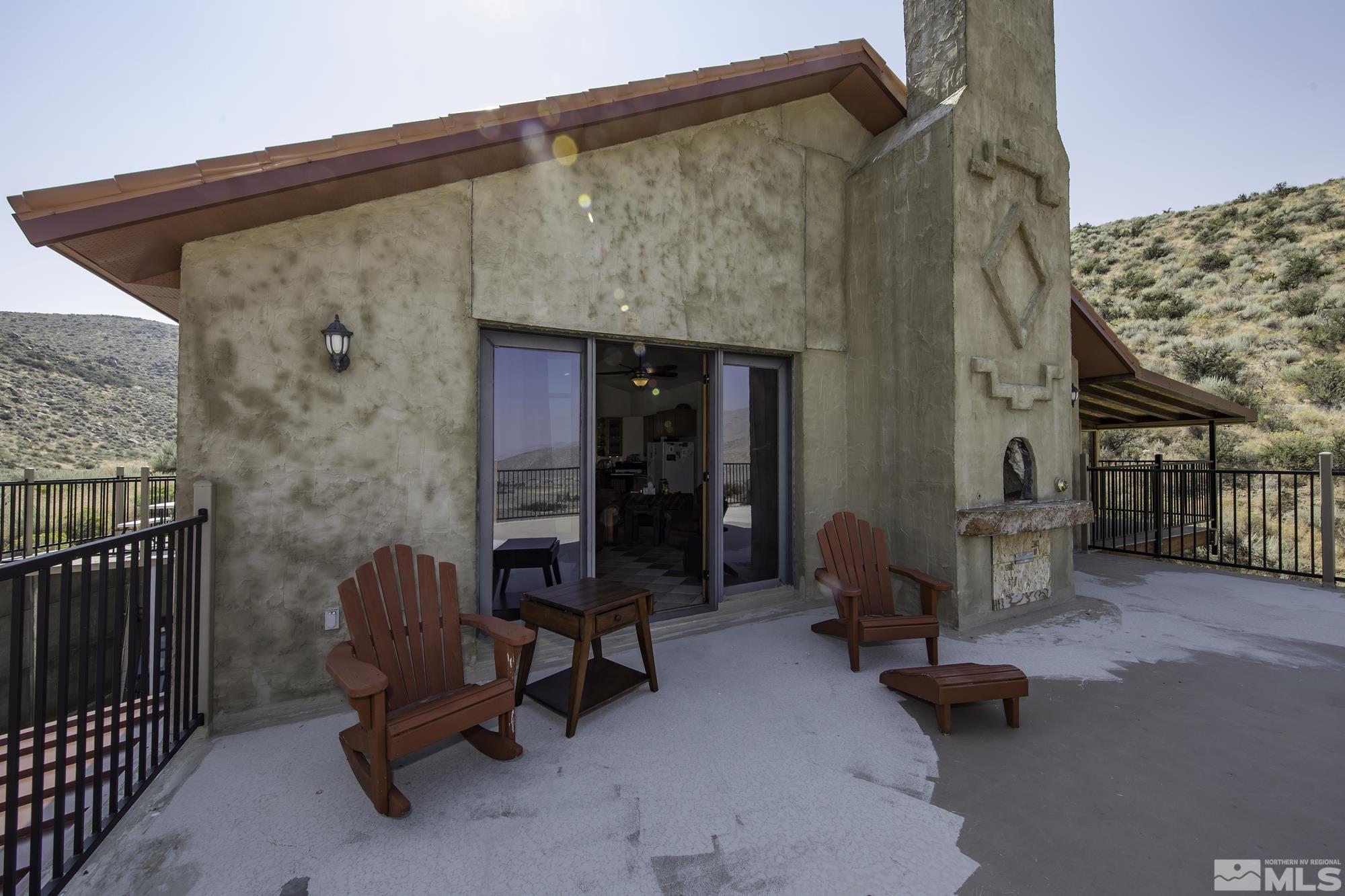 a backyard of a house with dining table and chairs